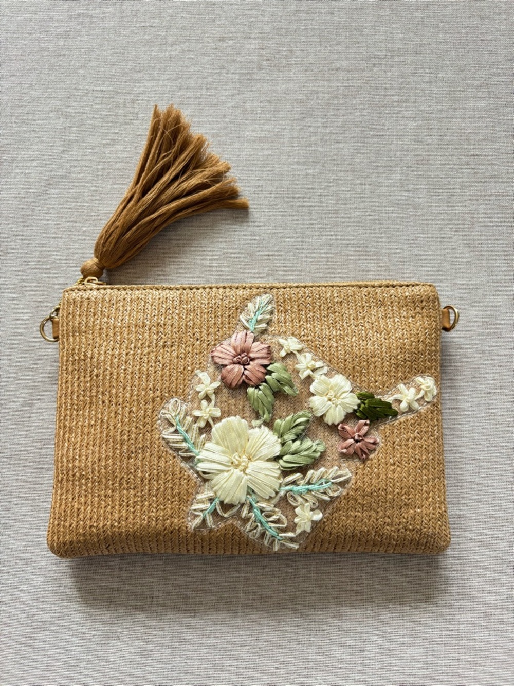 Tan embroidered ribbon clutch.